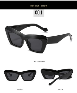 Macro view of triangular cat-eye sunglasses with thick black frames and dark grey lenses