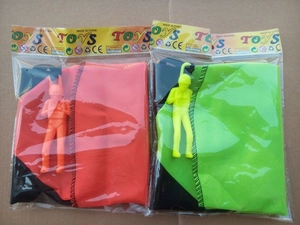 Detail view of large outdoor toy parachutes in orange and green with soldier figures