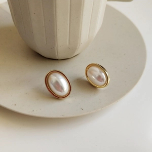 Detail view of 925 silver oval pearl earrings with elegant gold-plated edges