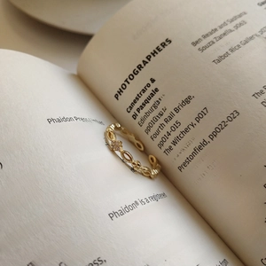 Detaillierte Makroansicht eines goldenen Vintage-Rings mit Zirkon auf Buchhintergrund