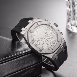 Men's silver sport watch with octagonal bezel and black rubber strap on leather background