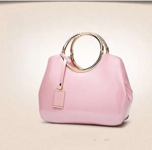 Pink glossy patent leather handbag with elegant golden double ring metal handles