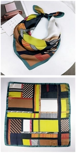 Close-up of geometric color block silk scarf with navy, yellow, and caramel patterns