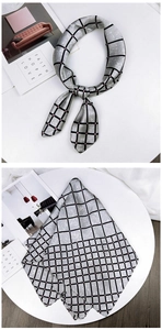 Detail view of a gray silk scarf with black grid pattern and pink dots for women