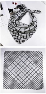 Detail of grey square silk scarf featuring black grid and pink polka dot patterns