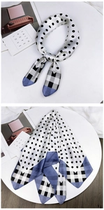 Close-up of silk scarf featuring black polka dots and plaid pattern on satin fabric