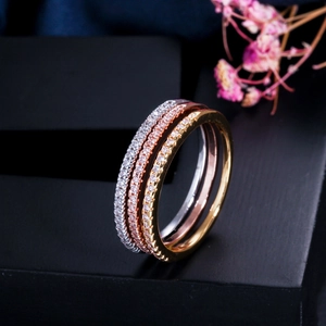 Macro detail of triple-layered gold rose gold and silver rings with AAA cubic zirconia