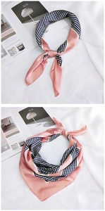 Detail showing elegant pink and navy blue polka dot silk scarf with smooth texture
