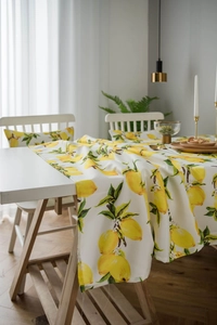 Detail of lemon print tablecloth and matching cushion in a stylish dining room setting