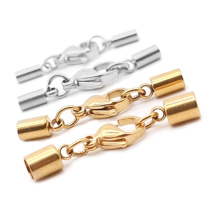 Macro detail of stainless steel lobster clasps with cord ends in gold and silver finish