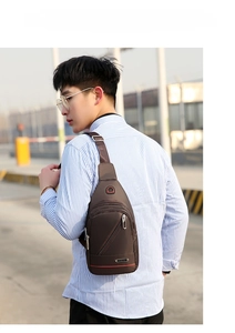 Outdoor shot of a man wearing a brown waterproof oxford fabric chest bag with red stripes