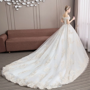 Elegant off-shoulder white wedding dress with champagne lace embroidery and a long luxury train