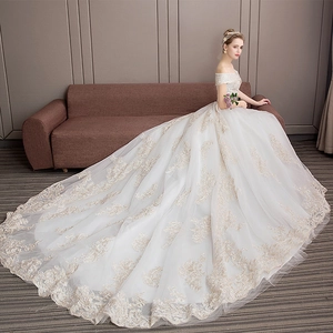 Elegant off-the-shoulder white wedding dress with champagne lace and long tulle train