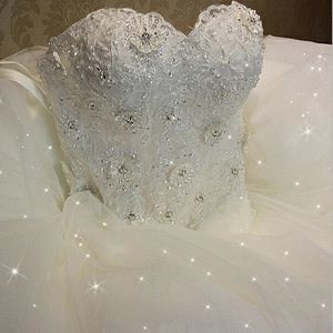 Elegant white strapless wedding dress with lace embroidery, pearls, and sequins detailing