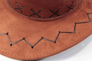 Detail of cross-stitch black decorative stitching on a brown suede cowboy hat brim