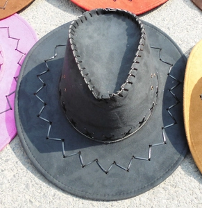Top-down shot of black cowboy hat detailing hand-stitched wave edges and metal air vents