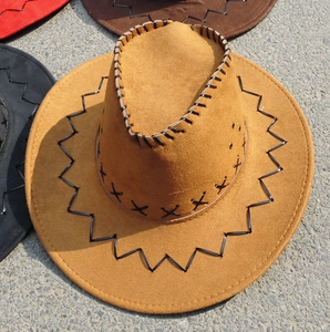 Detail of Western cowboy hat featuring rustic X-pattern stitching and metal air vents