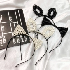 Detail view of pearl cat ear and rabbit ear headbands on a white silk background