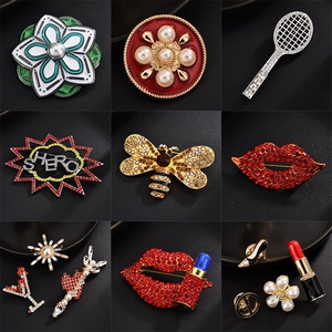 Collection of crystal lip and floral fashion brooches for women on a black background