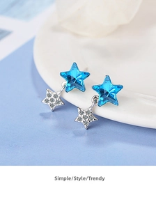 Detail of blue crystal star earrings with small silver dangling star and white zircons
