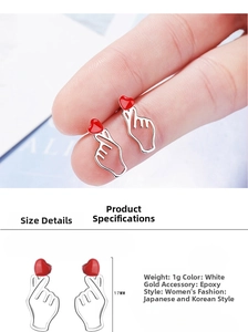 Detail view of 17mm finger heart earring in white gold finish with red enamel drop