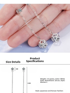 Detailed view of silver geometric cube long earrings with sparkling zircon stones