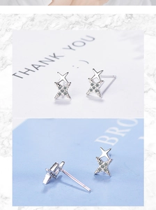 Macro detail of silver double star earrings with sparkling cubic zirconia inlay