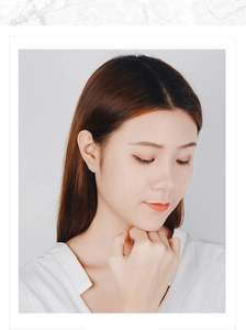 Close-up of a model wearing a sparkling silver snowflake stud earring with tiny crystals