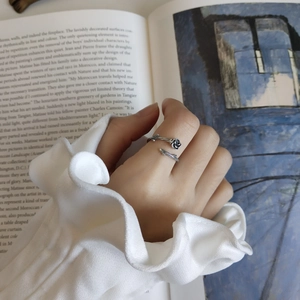 Detail of 925 sterling silver vintage rose ring worn by model over a book background