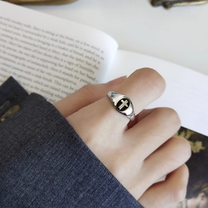 Close-up of vintage 925 silver ring featuring a black cross on a circular shield