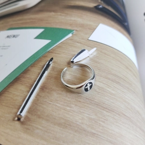 Macro detail of S925 sterling silver ring featuring a black enamel cross symbol
