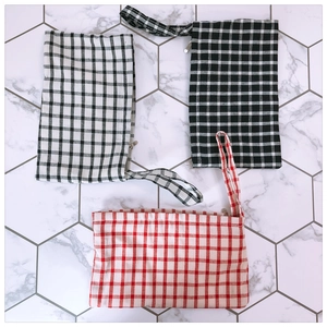 Three-piece set of checkered canvas coin purses with zip closures and wrist straps