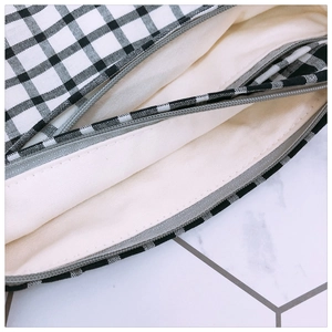 Detail view of plaid fabric bag featuring high-quality zipper and layered inner lining