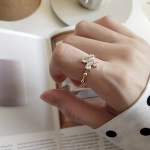 Gold plated 925 silver ring featuring a sparkling cross flower design on a woman's hand