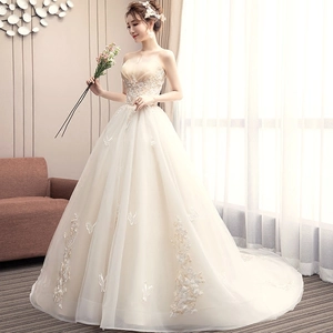 Elegant strapless champagne wedding dress with butterfly lace embroidery and a long train