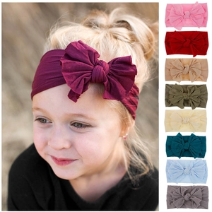 Soft nylon baby headband with a large bow shown in nine colorful elastic options