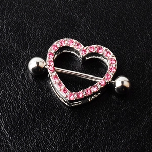 Close-up of heart-shaped nipple shield with pink crystals on black leather background