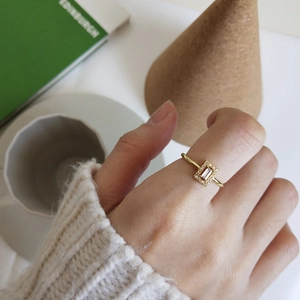 Minimalist gold ring with emerald cut clear stone and pave diamonds on female hand