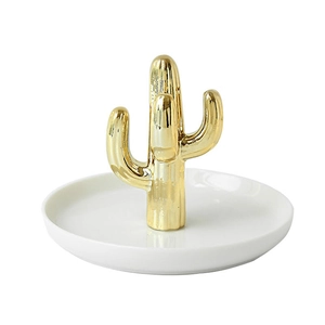 Detailed close-up of a white ceramic jewelry tray with a gold cactus shaped ring holder
