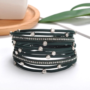 Close-up of green multi-layer leather bracelet with metal studs, rhinestones, and chain