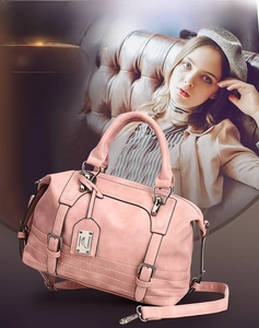 Close-up of pink Boston bag with premium leather texture, handles and metal hardware