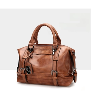 Side view detail of the vintage brown Boston bag showing PU leather texture and metal buckles