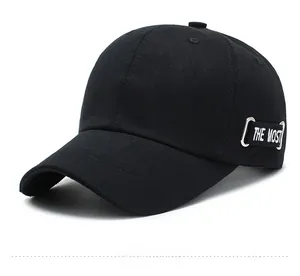Detail view of black cotton baseball cap with THE MOST embroidery and silver metal ring