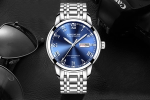 Detail of blue dial watch with date display, silver steel band on leather background