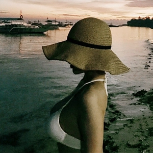 Handwoven straw sun hat with large brim and black ribbon for summer beach vacation