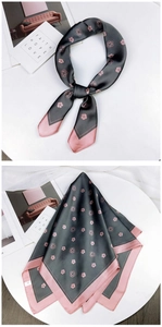 Detail of a square silk scarf with camellia print in grey and pink glossy fabric