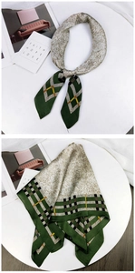 Detail of dark green and beige square silk scarf with geometric patterns and soft texture