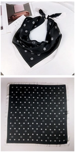 Detailed close-up of a black and white silk square scarf with floral camellia patterns