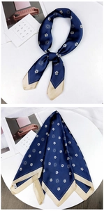 Detailed view of dark blue silk scarf with golden camellia pattern and satin finish
