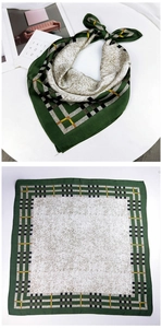 Detail of square silk scarf featuring dark green borders and retro mottled cream patterns